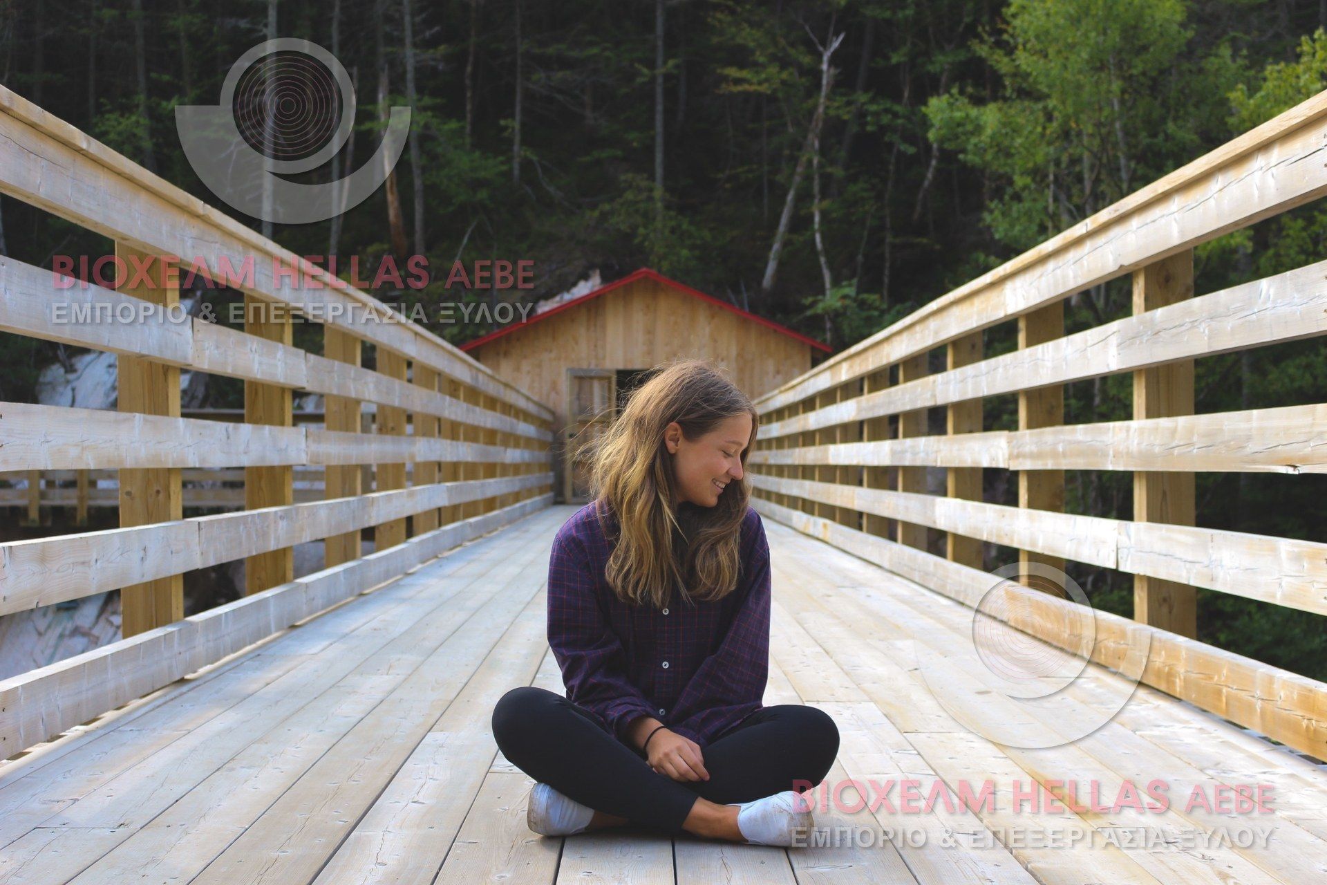woman sitting on wooden bridge in front of wooden house in forest