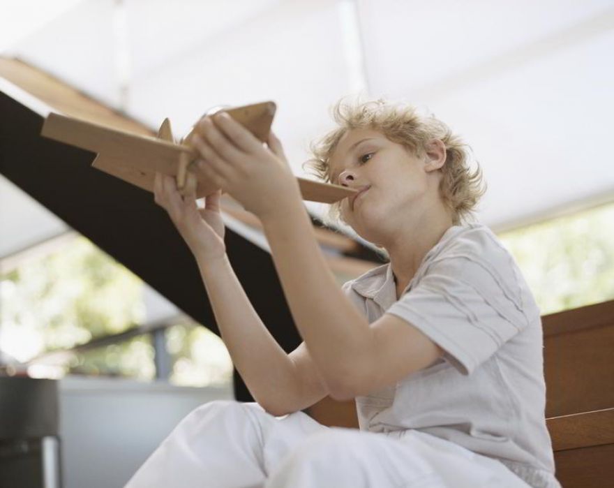 child-holds-wooden-aircraft